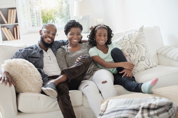 Black family smiling on sofa