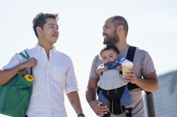 Gay fathers doing errands with baby son