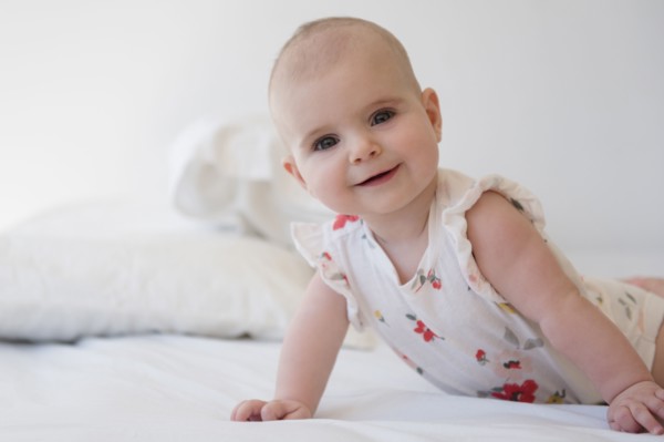 Caucasian baby girl crawling on bed