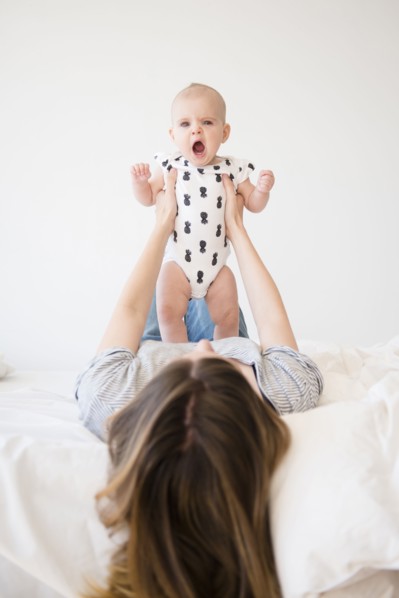 Caucasian mother holding baby daughter on bed
