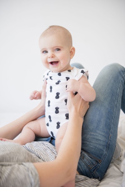 Caucasian mother holding baby daughter on bed