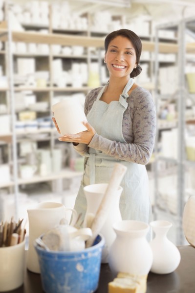Mixed race potter smiling in workshop