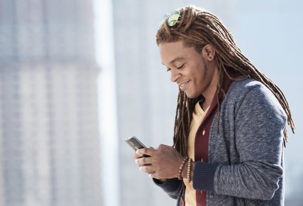 Mixed race man using cell phone outdoors