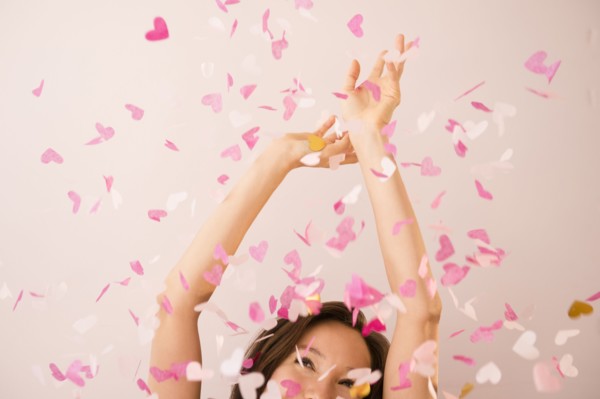Mixed race woman playing in confetti