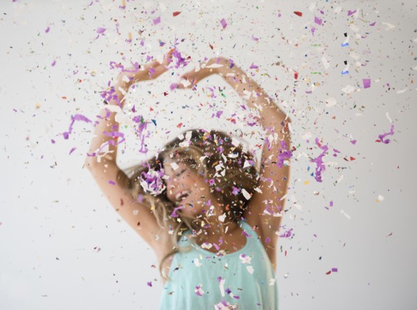 Mixed race woman playing in confetti