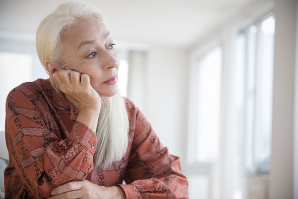Caucasian woman sitting with chin in hand