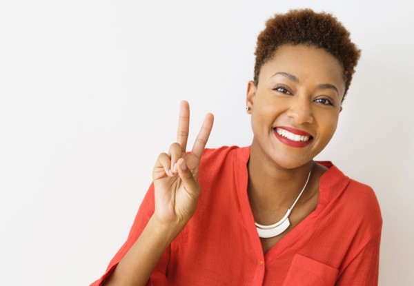 Mixed race woman making peace sign