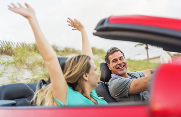 Caucasian couple driving in convertible