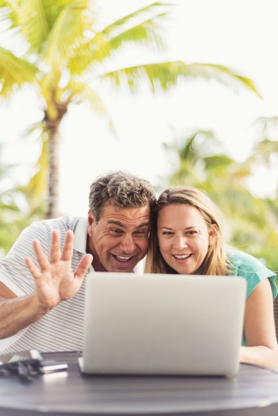 Caucasian couple video chatting on laptop outdoors