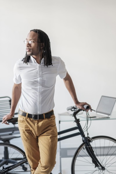 Black businessman with bicycle in office