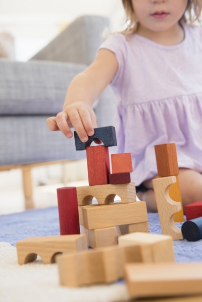 Caucasian girl playing with wooden blocks