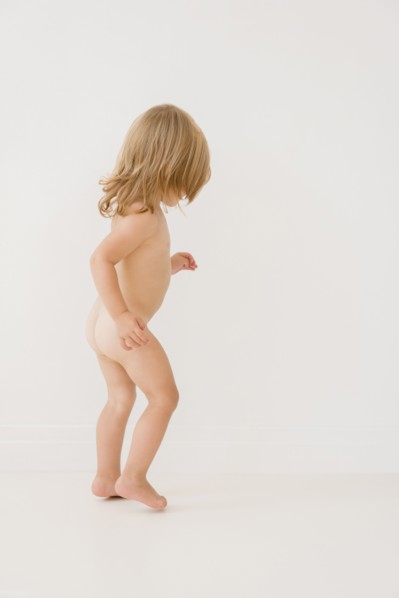 Portrait of nude Caucasian girl playing