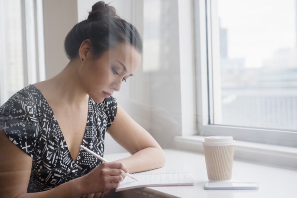 Woman writing in coffee shop