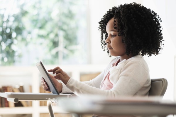 African American student using digital tablet in classroom