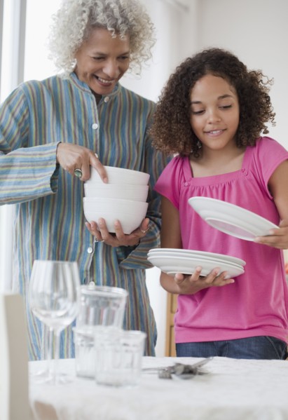 Grandmother and granddaughter setting table