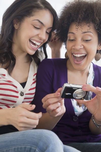 Friends looking at photographs on digital camera
