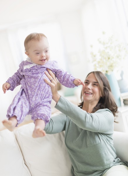 Caucasian mother playing with baby with Down Syndrome