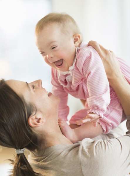 Caucasian mother playing with baby girl with Down Syndrome