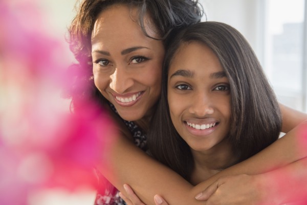 Smiling mother and daughter hugging