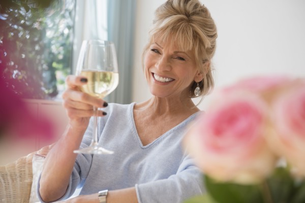Older Caucasian woman drinking white wine
