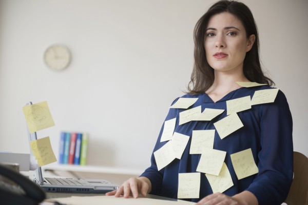 Blouse of stressed Caucasian businesswoman covered with adhesive notes