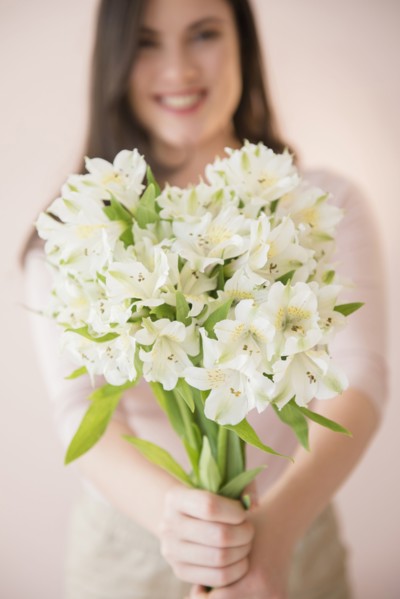 Caucasian woman holding bouquet of white flowers