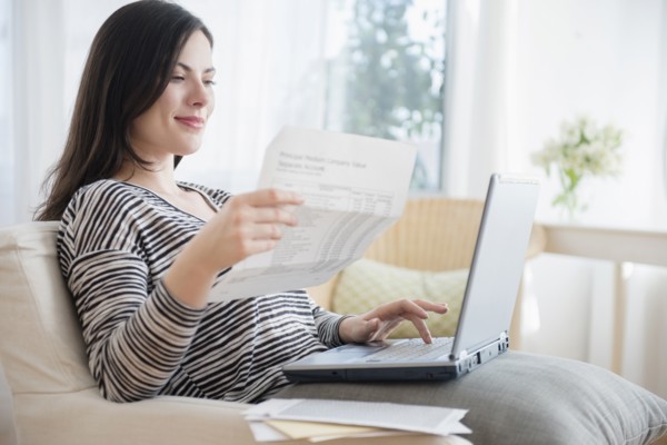 Caucasian woman paying bills using laptop