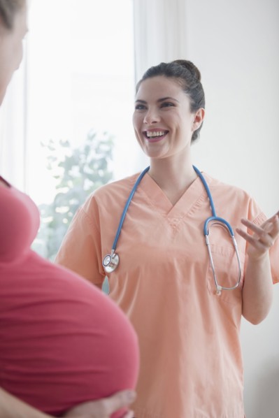 Caucasian nurse consulting with expectant mother