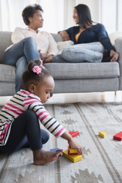 black baby girl playing on carpet with blocks