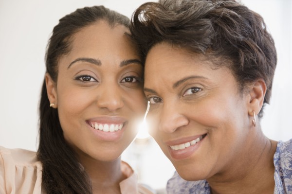 Smiling Black women posing cheek to cheek