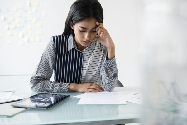 Indian businesswoman reading paperwork in office