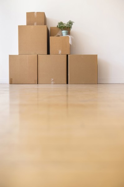 Cardboard boxes stacked against wall in empty apartment