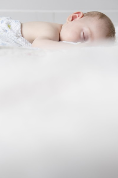 Caucasian baby boy sleeping on bed