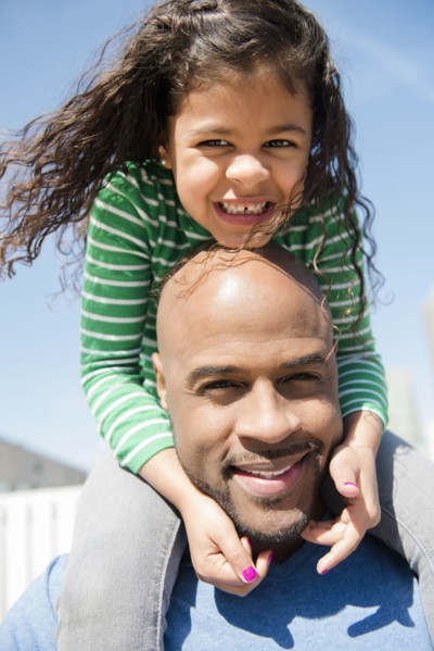 Father carrying daughter on shoulders