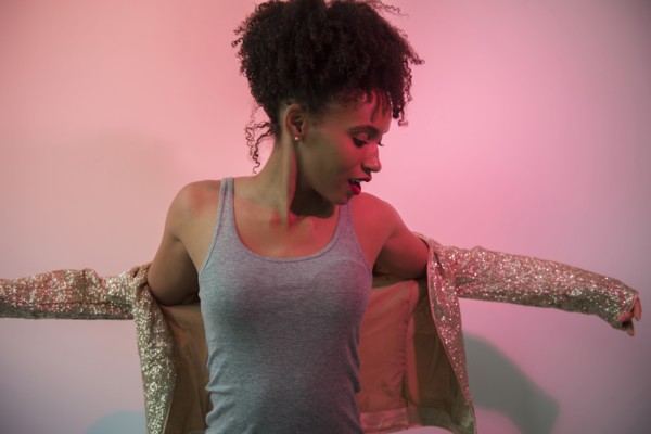 Black woman dressing in glamorous jacket