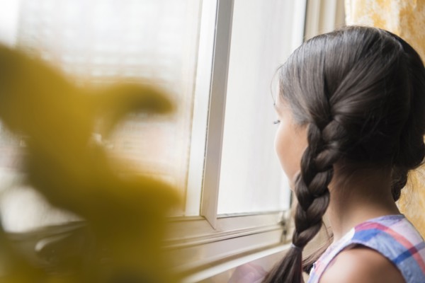 Mixed Race girl looking out window