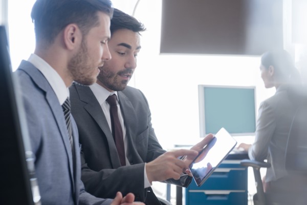 Businessmen using digital tablet in office