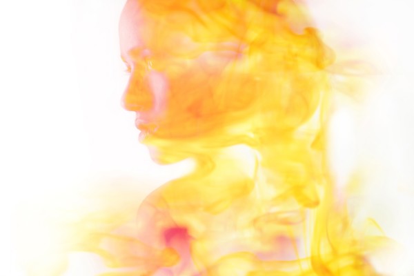 Double exposure of face of Mixed Race woman and fire