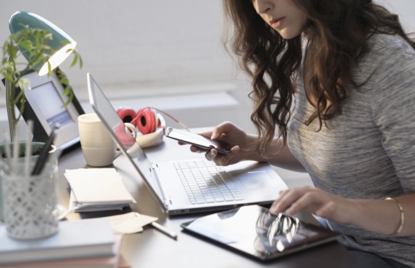Hispanic businesswoman using technology in office