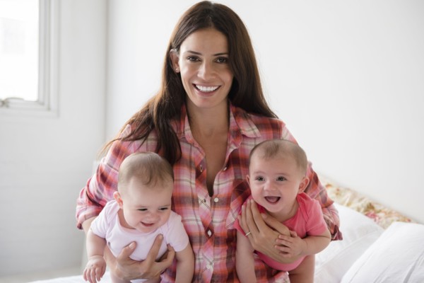 Caucasian mother holding twin baby daughters