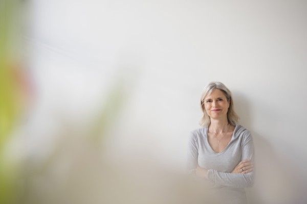 Smiling Caucasian woman leaning on wall