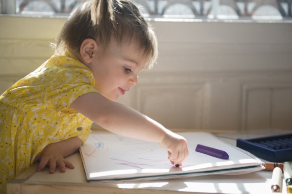 Caucasian baby girl coloring on sketchpad