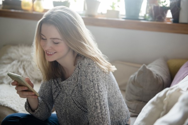 Smiling woman texting on cell phone