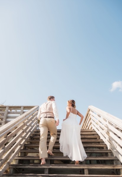 Caucasian bride and groom climbing wooden staircase