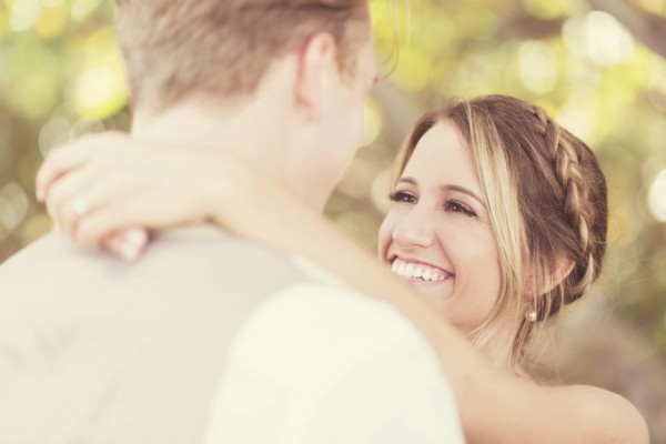 Caucasian bride and groom hugging outdoors
