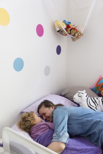 Caucasian mother and daughter laughing and cuddling in bed