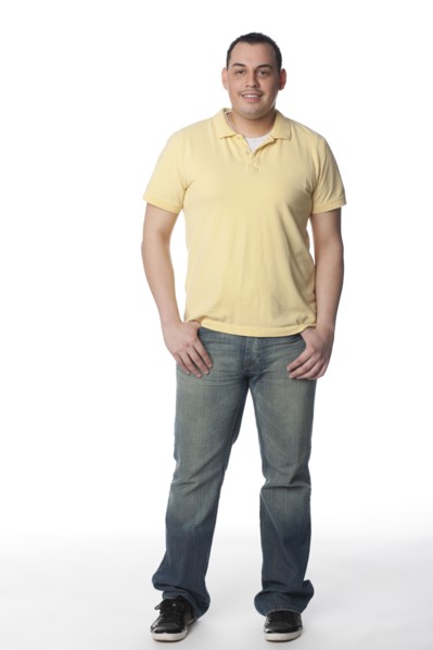 Smiling Hispanic man with hands in pockets