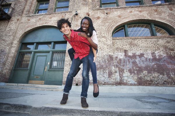 Boyfriend giving girlfriend piggyback ride in urban area