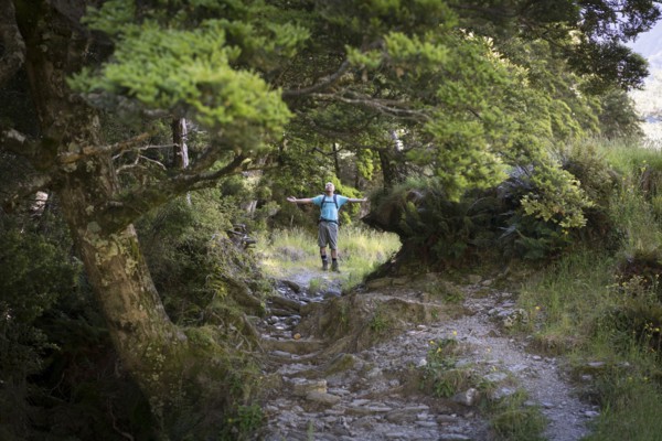 Chinese man standing in forest path