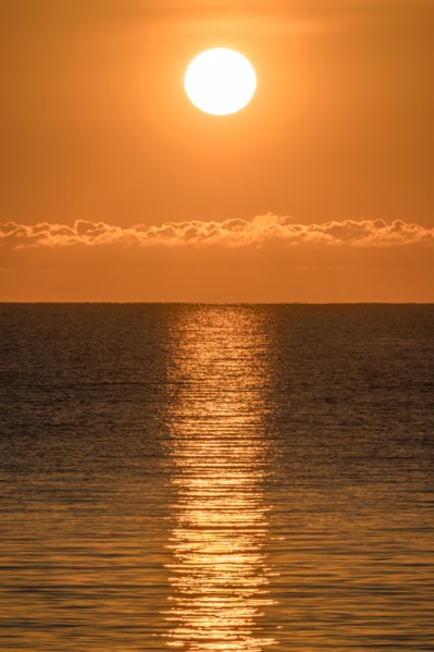 Blazing sunrise in orange sky over ocean